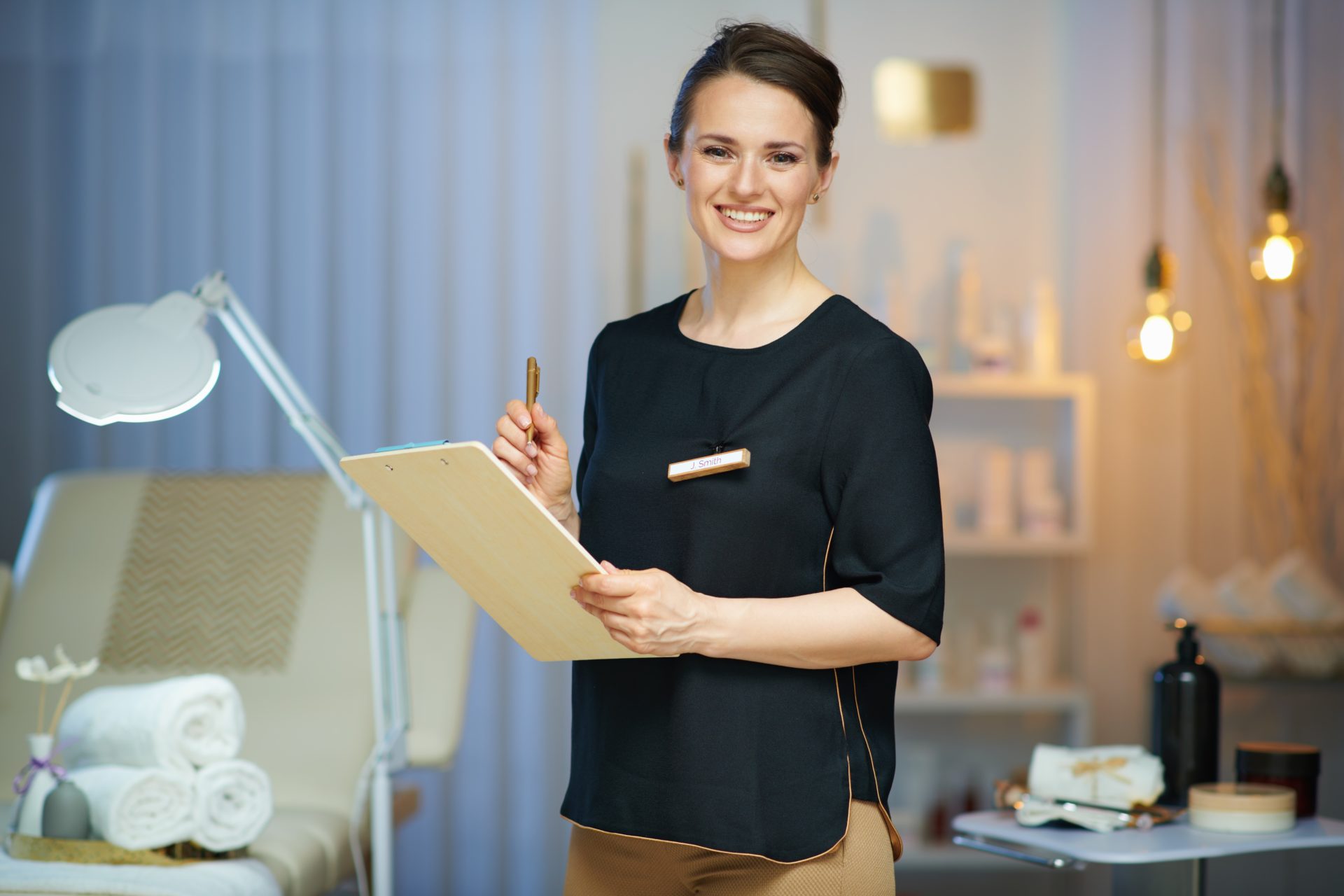medical spa owner with clipboard in front of spa chair